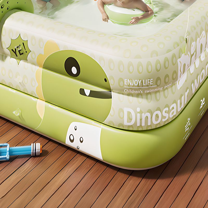 Detailaufnahme des Dino-Wassersprühers am aufblasbaren Kinderplanschbecken mit UV-Sonnendach im Garten.