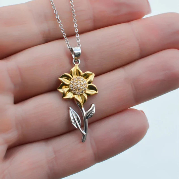 Filigrane Damenkette in Gold mit leuchtendem Sonnenblumen-Anhänger und schimmerndem Kristall.