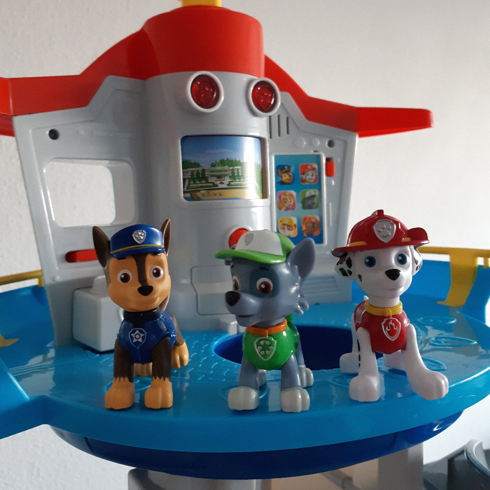 Kinderhände spielen mit bunten Autos auf dem Rutschenturm. Lernspielzeug für Kreativität und Rollenspiel.