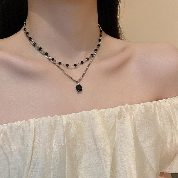 Moderne Statement Doppelkette in Schwarz-Silber mit schimmernden schwarzen Perlen; ideal als Damenschmuck.