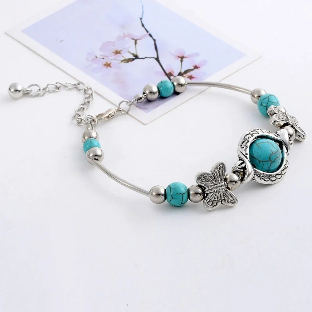 Filigranes Damen Armband aus Sterlingsilber mit leuchtenden Türkisperlen und zartem Schmetterling Anhänger.
