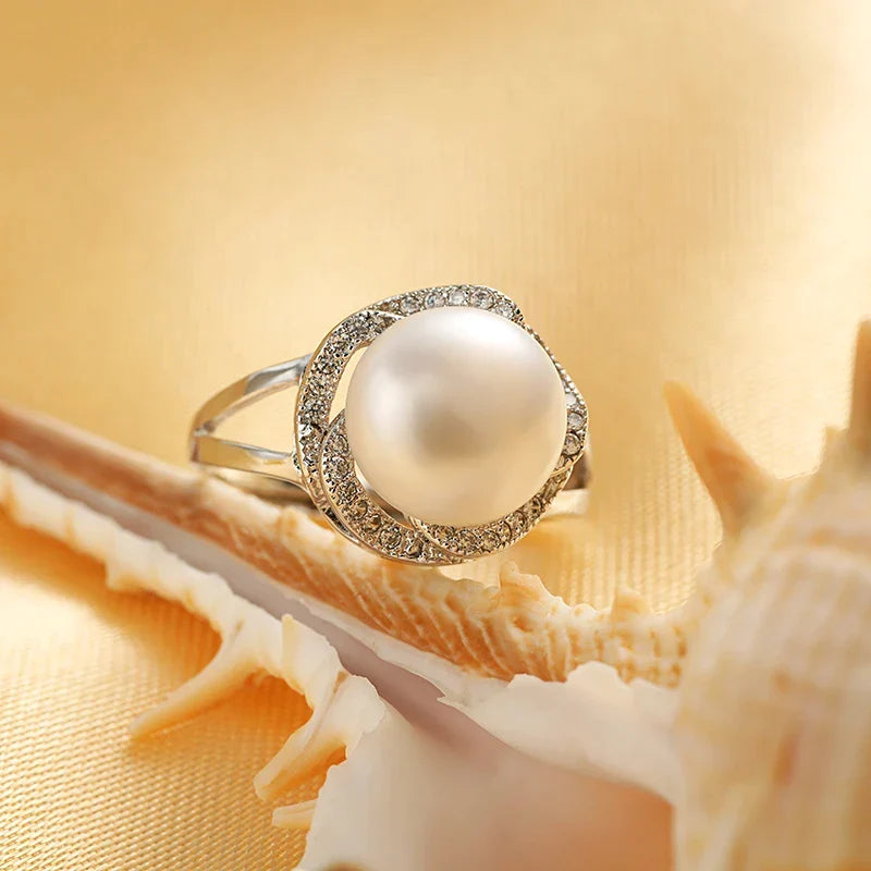 Klassischer Damen Perlenring aus Silber mit schimmernder Süßwasserperle am Finger getragen. Verstellbar für Komfort.