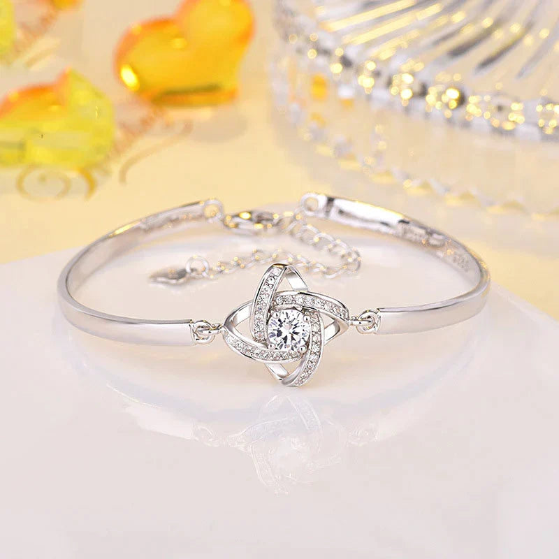 Rundes Damen Liebesknoten Armband aus glänzendem Edelstahl mit funkelnden Zirkonia-Akzenten, ein schönes Schmuckstück.