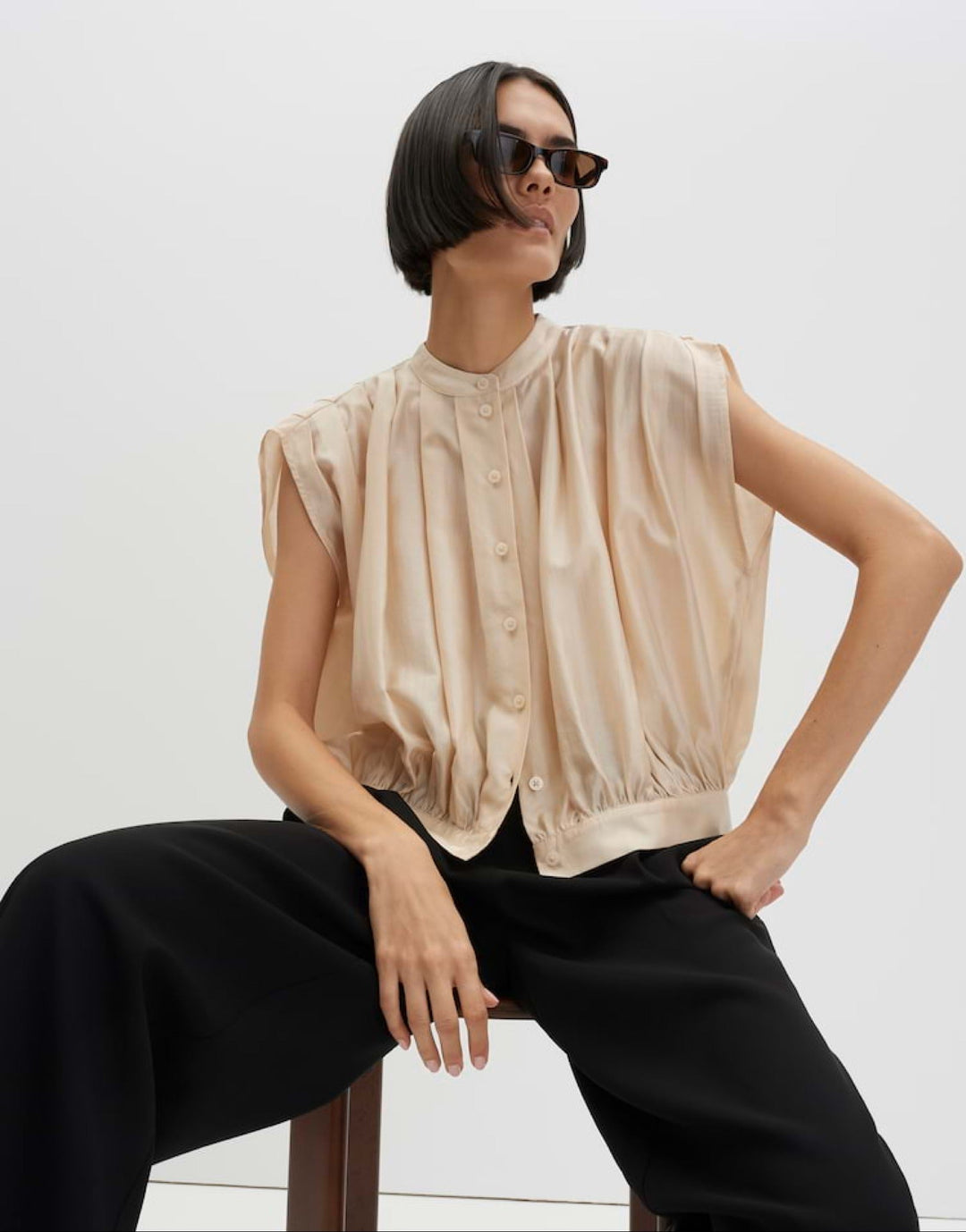 Detailansicht der raffinierten Drapierung einer eleganten Damenbluse. Rundhalsausschnitt, ideal als Sommerbluse.
