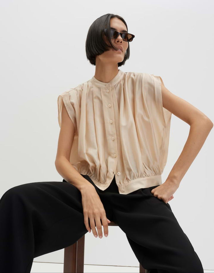 Detailansicht der raffinierten Drapierung einer eleganten Damenbluse. Rundhalsausschnitt, ideal als Sommerbluse.