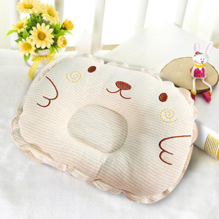 Beiges Babykopfkissen mit Mulde gegen Kopfverformung und Plattkopf Syndrom. Orthopädisches Kissen für Babys.