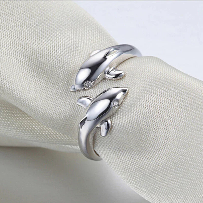 Detailaufnahme des Damen-Silberrings mit zwei kunstvoll geformten Delfinen, glänzend & elegant.