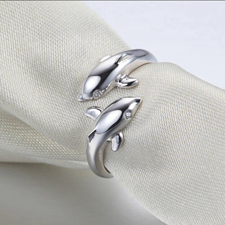 Detailaufnahme des Damen-Silberrings mit zwei kunstvoll geformten Delfinen, glänzend & elegant.