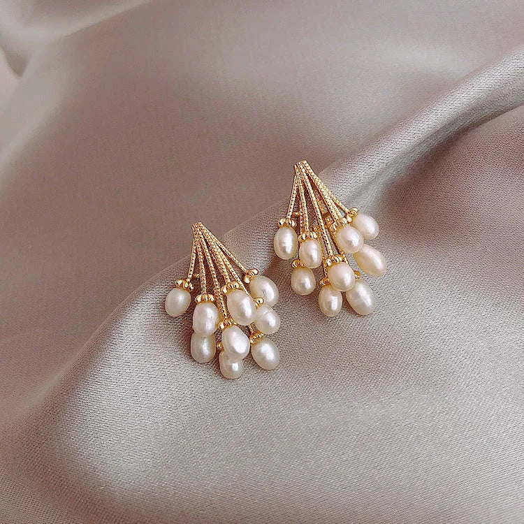 Detailaufnahme von Damen-Ohrringen: 18K vergoldet mit feinen Perlenquasten. Ein stilvolles Schmuck-Accessoire.