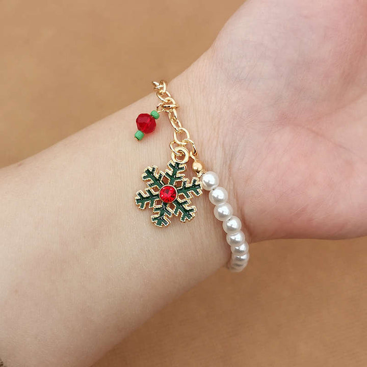 Detailansicht: Damen Charm-Armband mit glänzenden Perlen, Schneeflocken & Weihnachtsmann-Anhängern.