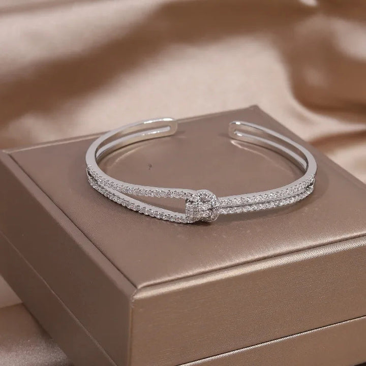 Modernes silbernes Damenarmband im Knoten-Design, ein stilvolles Manschettenarmband aus Edelstahl für Eleganz.