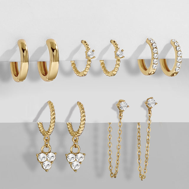 Detailansicht: Funkelnde Zirkonia-Steine auf goldenen Retro Herzohrringen für Damen.