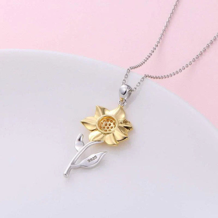 Goldene Damenkette mit Sonnenblumen-Glücksbringer, verziert mit einem strahlenden Kristall.