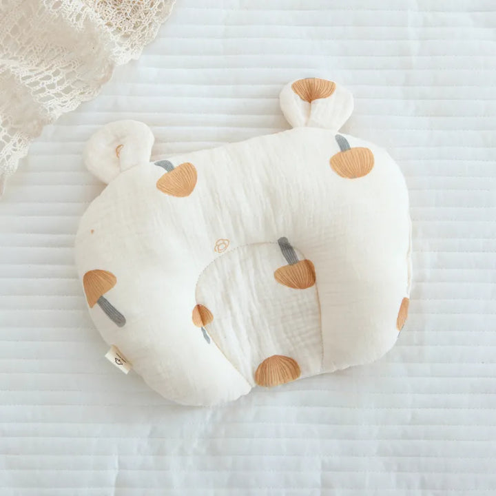 Weiches Babykissen aus atmungsaktiver Baumwolle, ergonomisch geformt für Säuglinge, beugt Kopfverformungen vor.