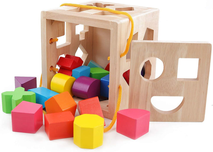 Kind spielt mit Montessori Holz-Lernwürfel, steckt bunte Formen in die passenden Öffnungen, fördert Konzentration.