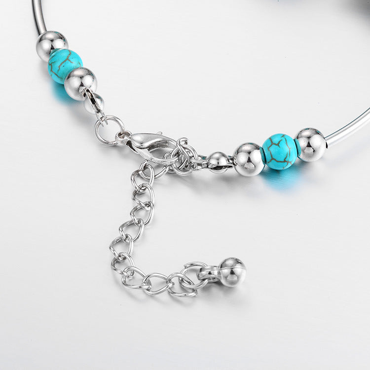 Leuchtendes Türkisperlenarmband für Damen, verziert mit einem filigranen Schmetterling aus Sterlingsilber.