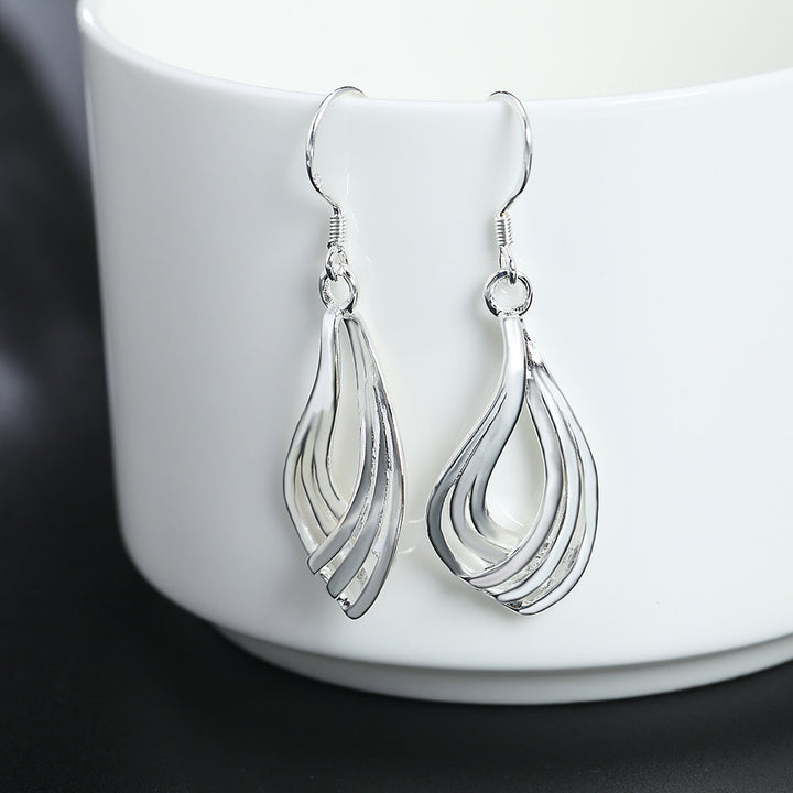 Nahaufnahme verdrehter Wellenlinien-Ohrringe aus 925er-Sterlingsilber, detaillierter Schmuck.
