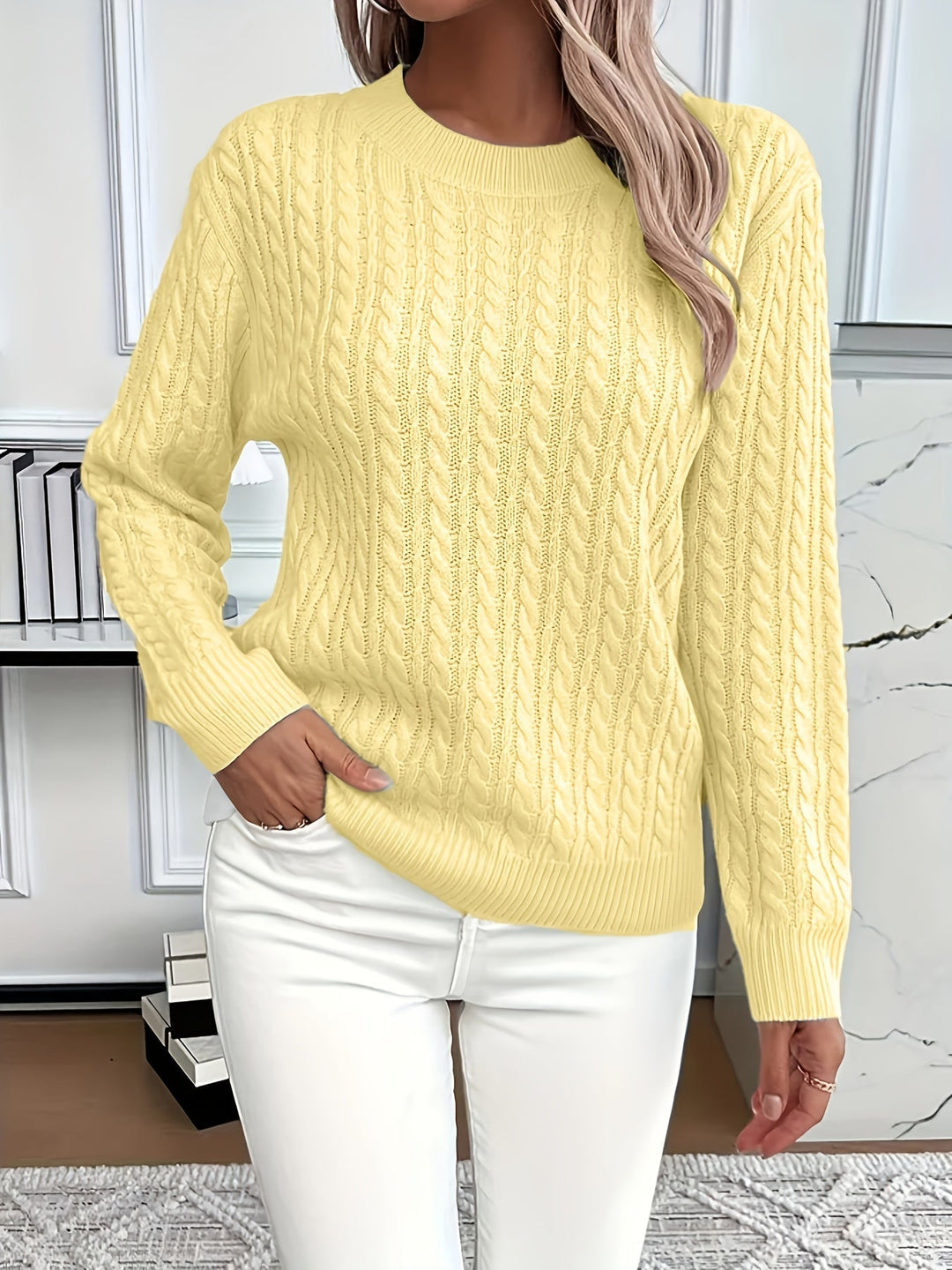 Model trägt lässigen Damen Strickpullover mit Zopfmuster und Rundhalsausschnitt für Frühling/Herbst.