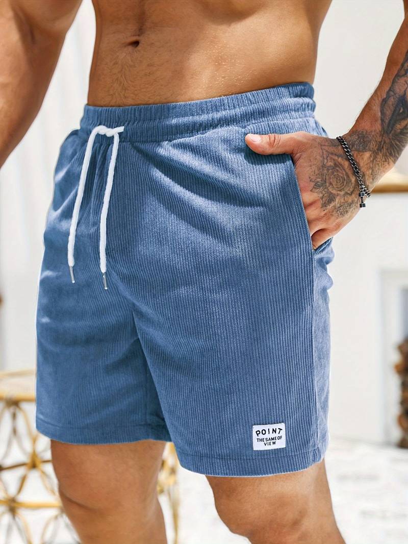 Mann trägt bequeme Herren-Strandshorts am Meer, perfekt für Schwimmen, Sport & Sonne. Lässiger Stil.