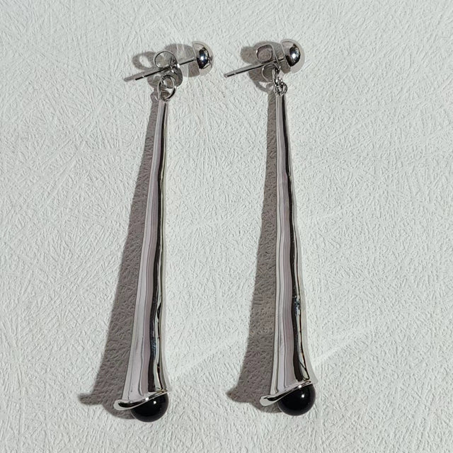 Nahaufnahme von stilvollen Damenohrringen in Tropfenform, aus hochwertigem Edelstahl gefertigt. Moderner Schmuck.