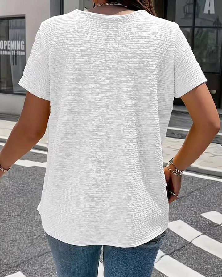 Detailaufnahme: Goldknöpfe & strukturierter Stoff dieser femininen Damen Kurzarm-Bluse mit elegantem Kragen.