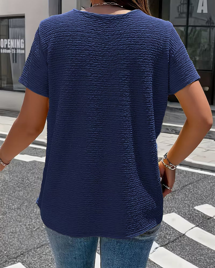 Rückenansicht der strukturierten Damen Bluse, Kurzarm-Top mit elegantem Kragen. Vielseitiges Sommer-Oberteil.