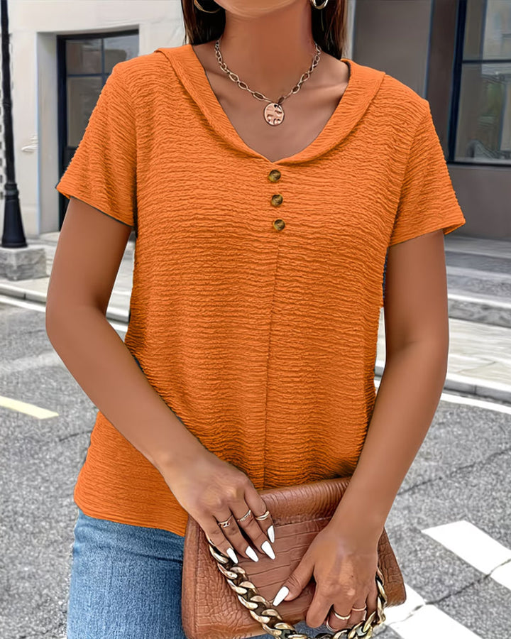 Naheinstellung: Der strukturierte Stoff dieser femininen Damen Bluse. Kurzarm-Top mit Goldknöpfen & Kragen.