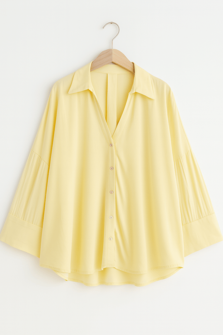 Model trägt gestreifte Damenbluse mit 3/4-Ärmeln und lockerem Schnitt. Elegante Frühlingsmode.
