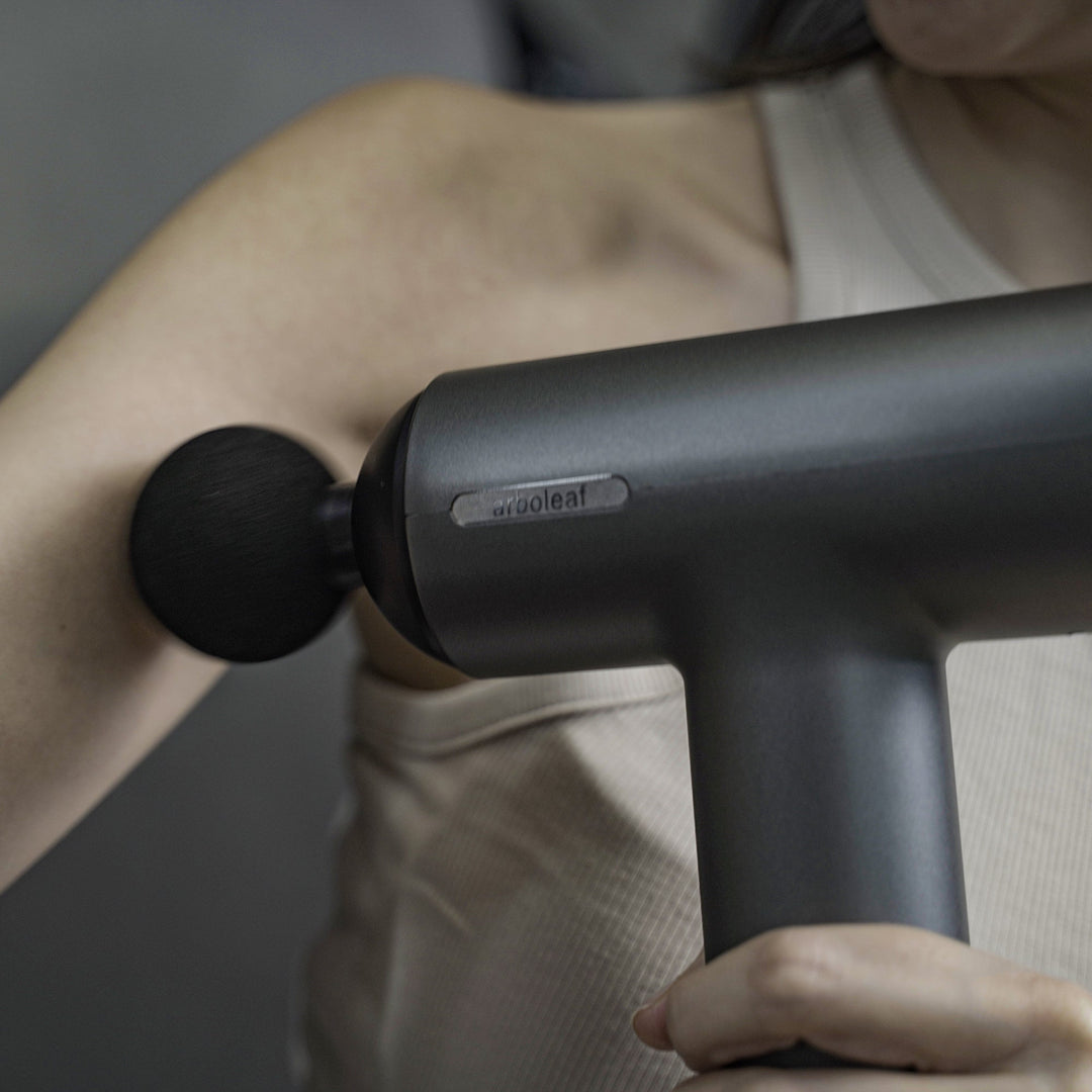 Ergonomisches Muskelmassagegerät mit verschiedenen Aufsätzen für effektive Regenerationshilfe.
