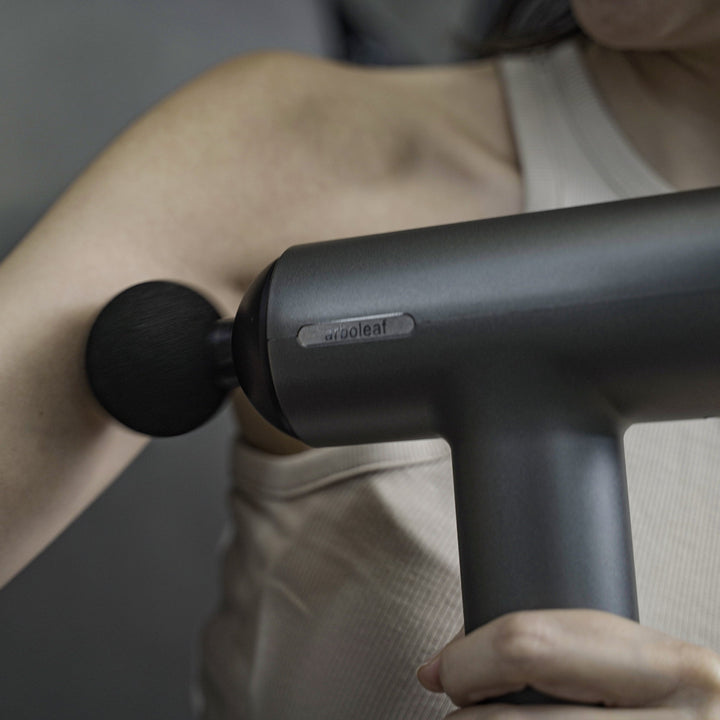 Ergonomisches Muskelmassagegerät mit verschiedenen Aufsätzen für effektive Regenerationshilfe.