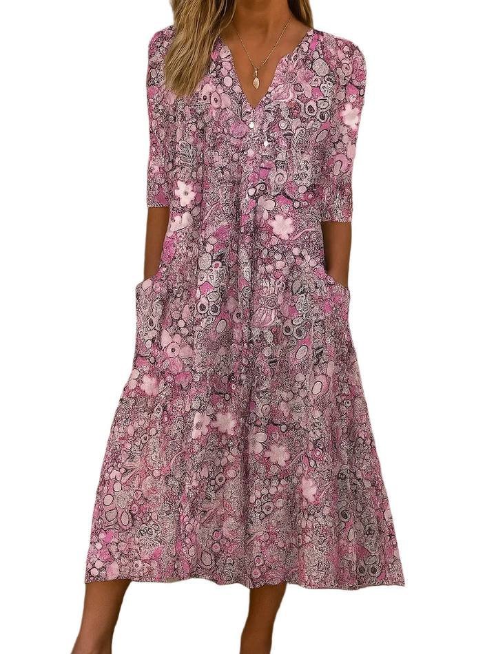 Detailansicht des Blumen Midikleids: V-Ausschnitt, 3/4-Ärmel & seitliche Taschen, zeigt die lockere Passform des Sommerkleids.