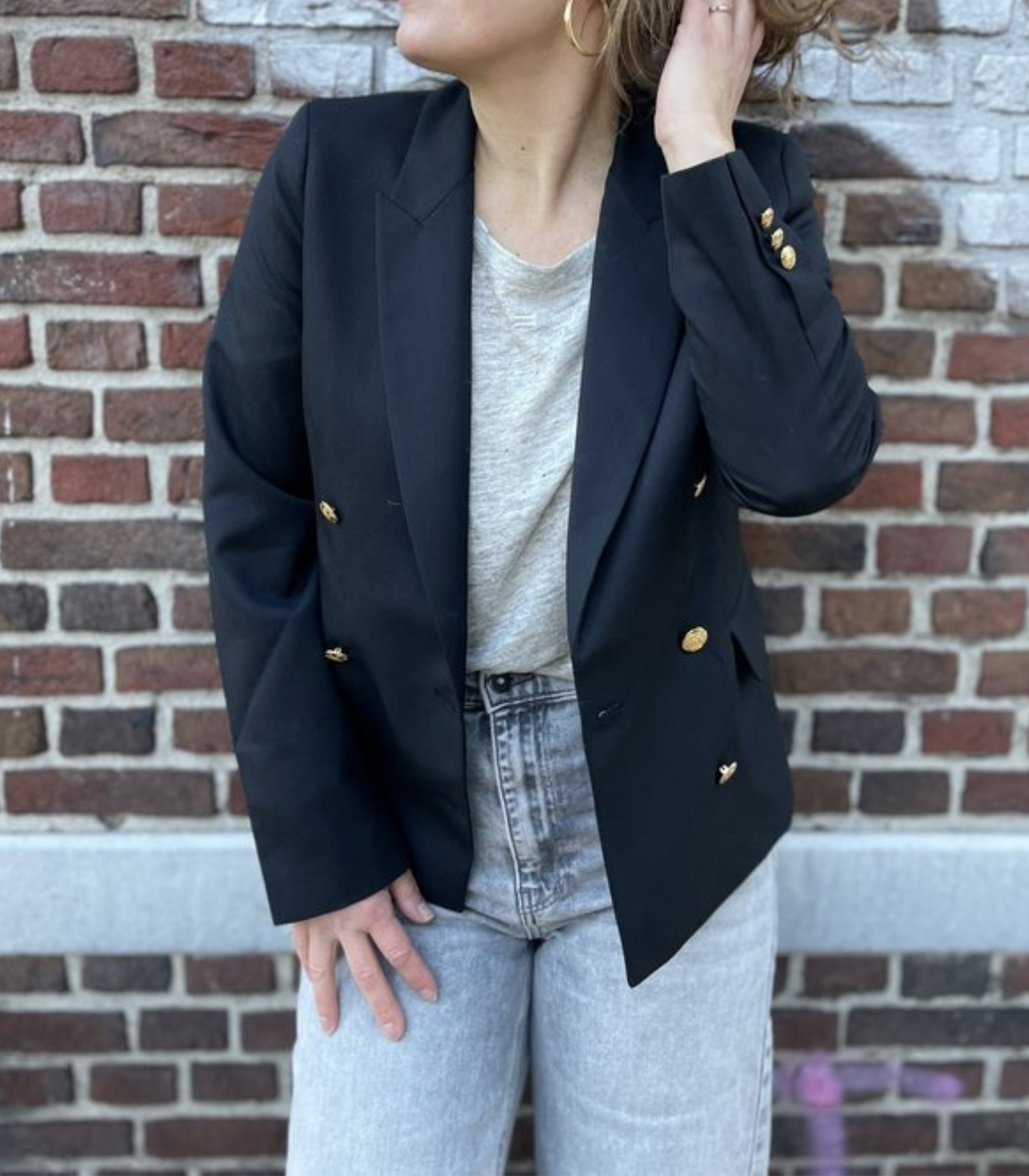 Eleganter schwarzer Damenblazer mit glänzenden Goldknöpfen. Perfekt für Business und schicke Anlässe.