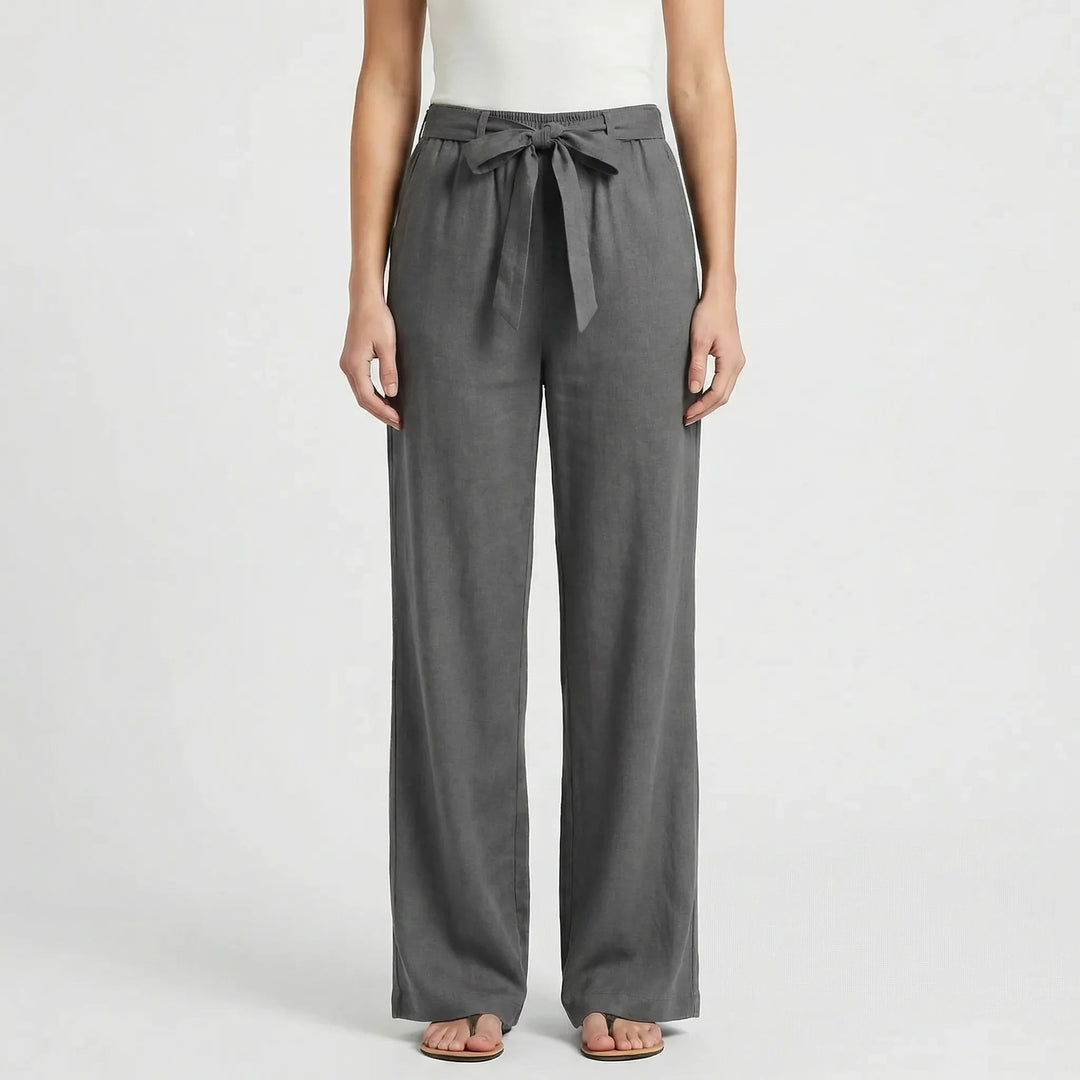 Frau im Business-Outfit: Elegante weite Bürohose mit Bindegürtel & Bluse. Zeitlose Damenmode.