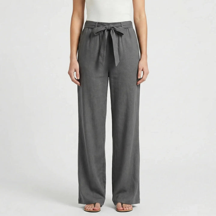Frau im Business-Outfit: Elegante weite Bürohose mit Bindegürtel & Bluse. Zeitlose Damenmode.