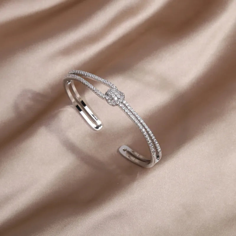 Exklusiver Kristallarmreif für Damen, verziert mit einem detailreichen Goldknoten Design.