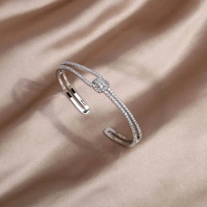 Exklusiver Kristallarmreif für Damen, verziert mit einem detailreichen Goldknoten Design.