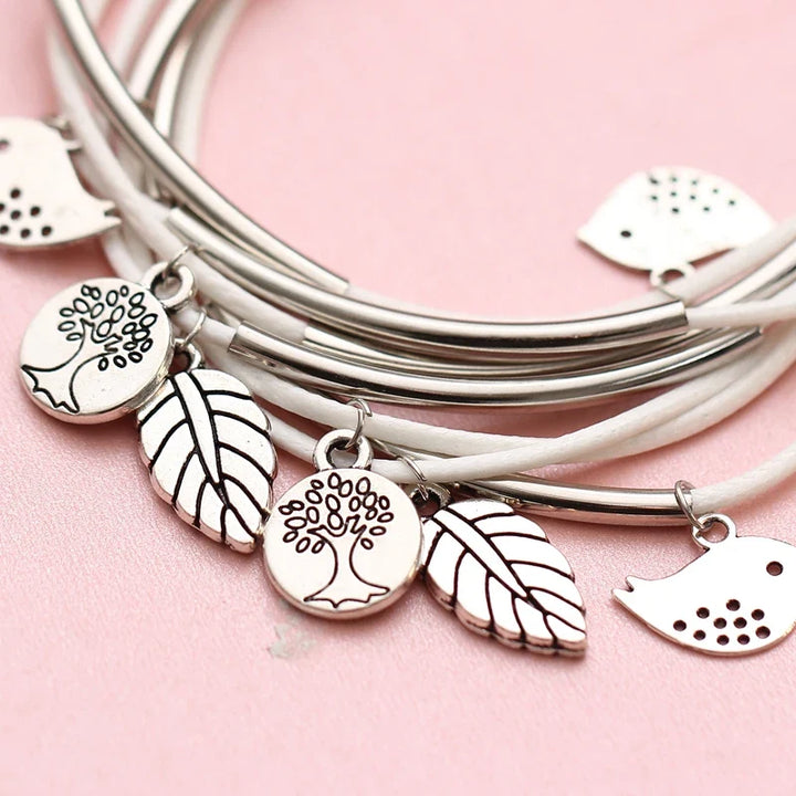 Accessoire: Mehrschichtiges Armband mit Blatt- und Vogel-Anhängern.