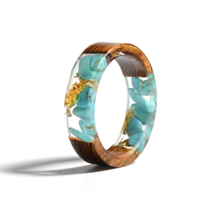 Nahaufnahme eines einzigartigen Holzharzrings, Naturholz mit transparentem Harz, handgefertigter Bandring.