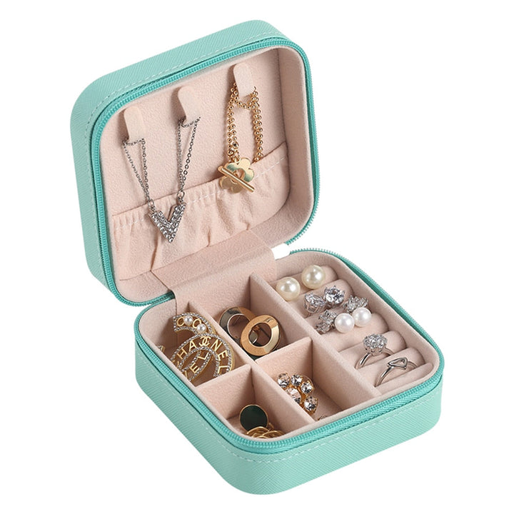 Offener Reiseschmuck-Organizer mit verschiedenen Fächern für Ringe, Ketten & Ohrringe.