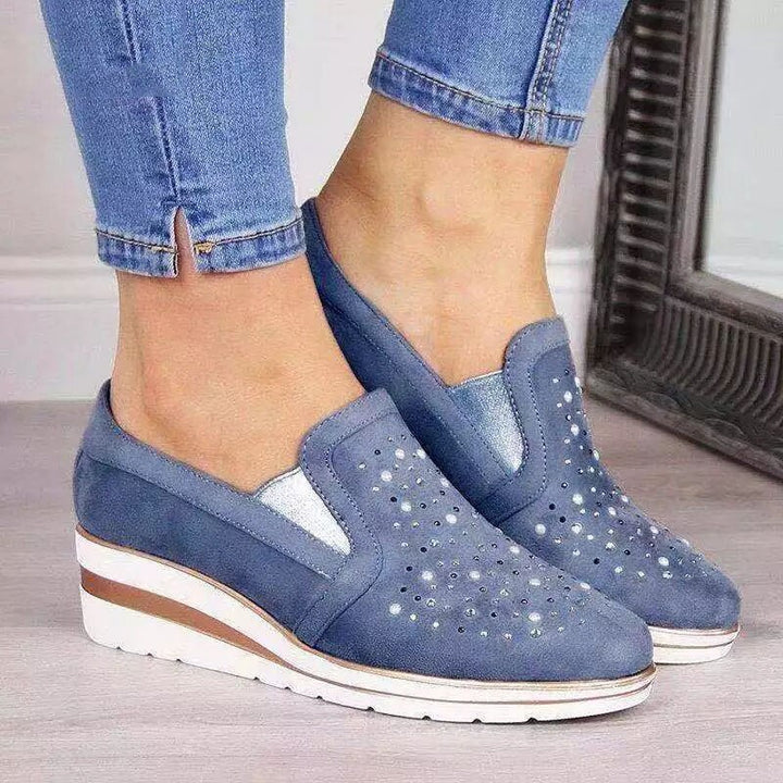Zwei Paar bequeme Damensneaker auf Holzuntergrund, bereit für den entspannten Herbst-Alltag.