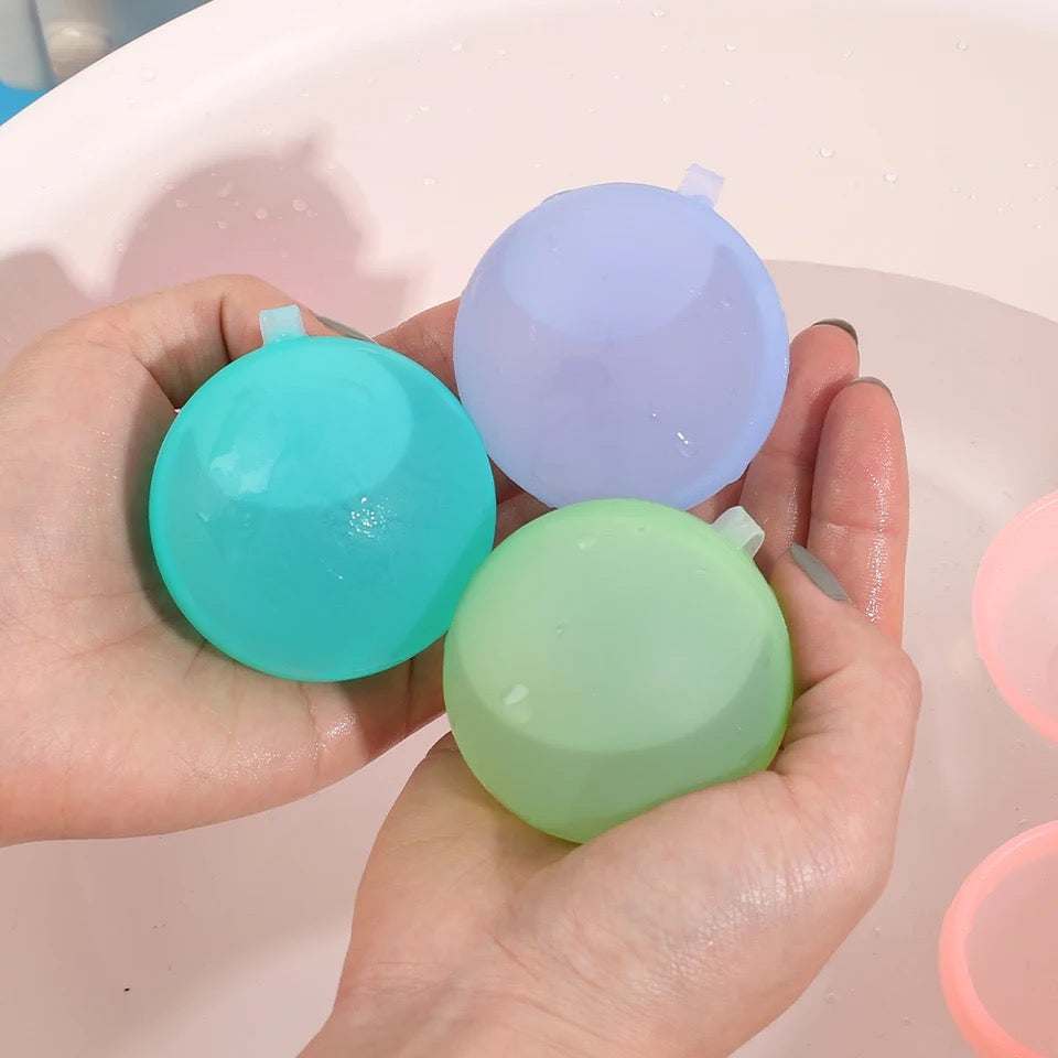 Familie spielt mit nachhaltigen, wiederverwendbaren Wasserbomben im Garten. Ideale Abkühlung für Kinder im Sommer.