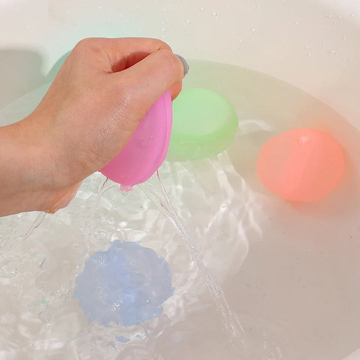 Lachende Kinder werfen wiederverwendbare Wasserbomben. Umweltfreundliches Wasserspielzeug für unvergesslichen Sommerspaß.