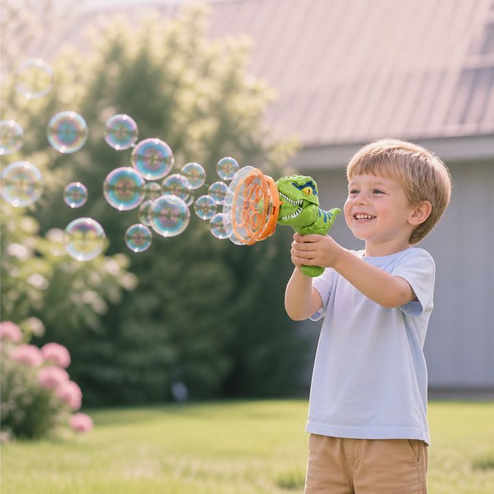 Glückliches Kind spielt mit Dino Seifenblasenkanone im Garten. Schönes Sommer-Spielzeug für große Seifenblasen.