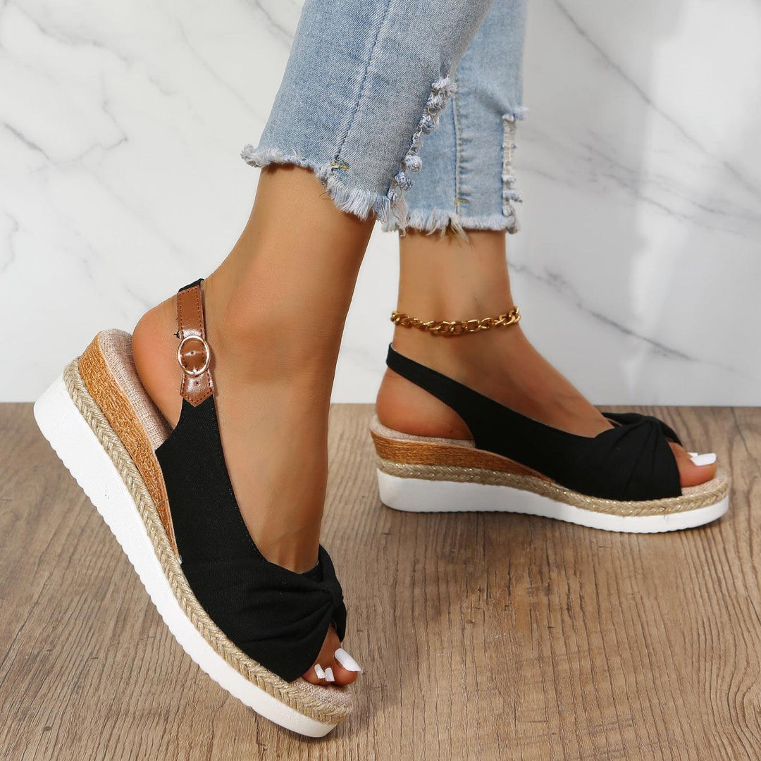 Elegante Damenschuhe: Schwarze Keilsandalen mit Plateau für einen stilvollen Sommer-Look.