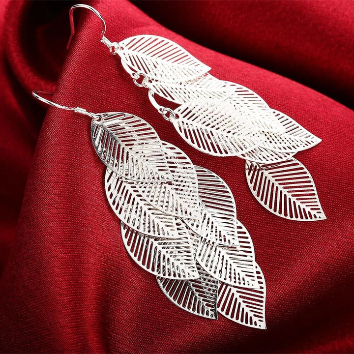 Elegante, filigrane Blatt-Ohrringe für Damen. Silberfarbener Naturschmuck, zartes Design für stilvolle Frauen.