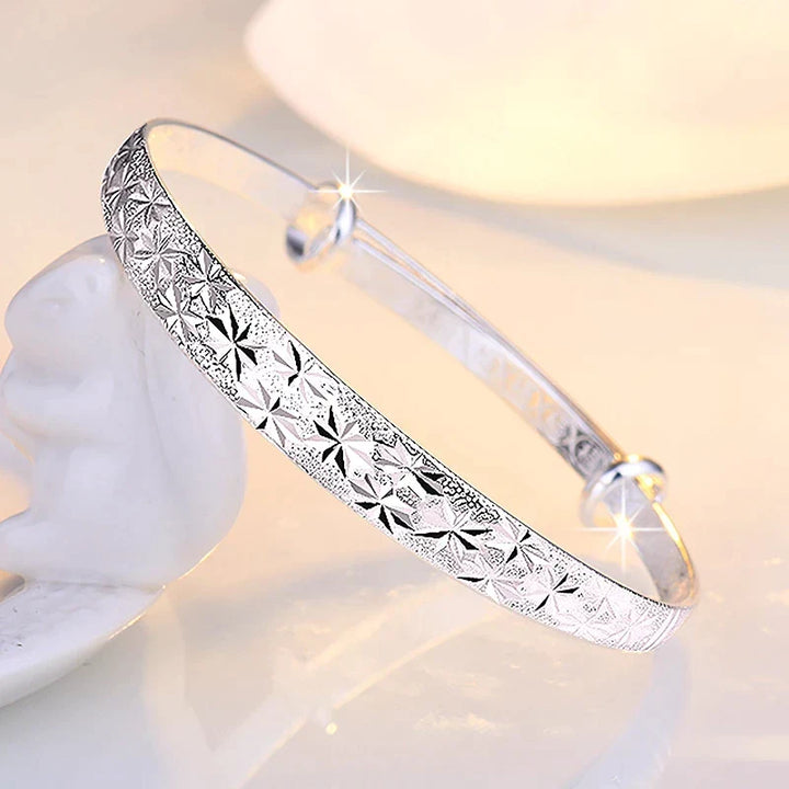 Handgefertigtes Damen-Schmuckarmband in Silberoptik mit leuchtenden Sternen, sehr stilvoll.