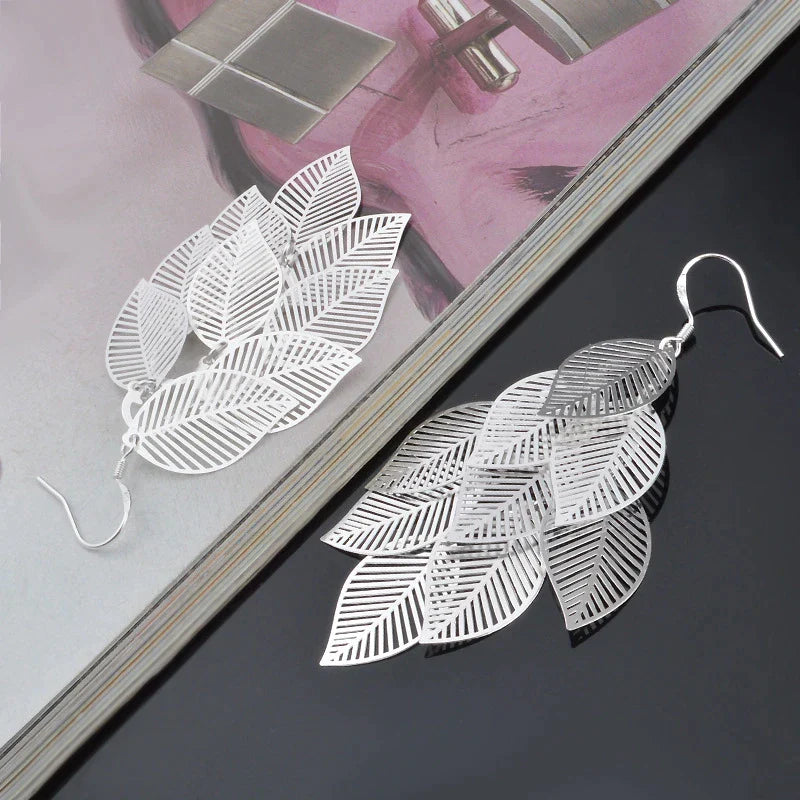 Nahaufnahme: filigrane Damen-Blatt-Ohrringe. Detailreicher Naturschmuck, elegante Hängeohrringe für Frauen.