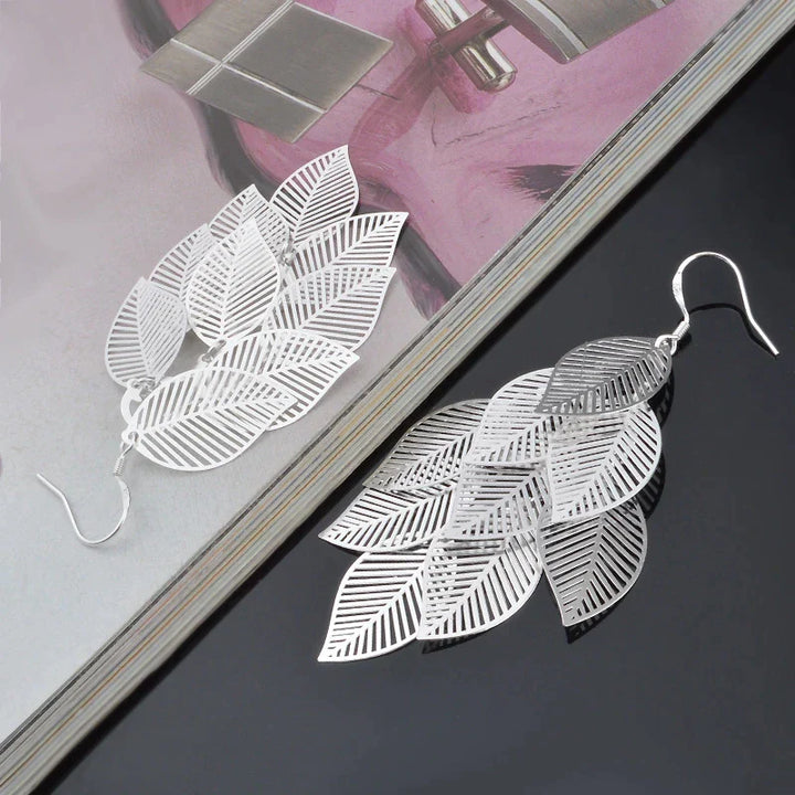Nahaufnahme: filigrane Damen-Blatt-Ohrringe. Detailreicher Naturschmuck, elegante Hängeohrringe für Frauen.