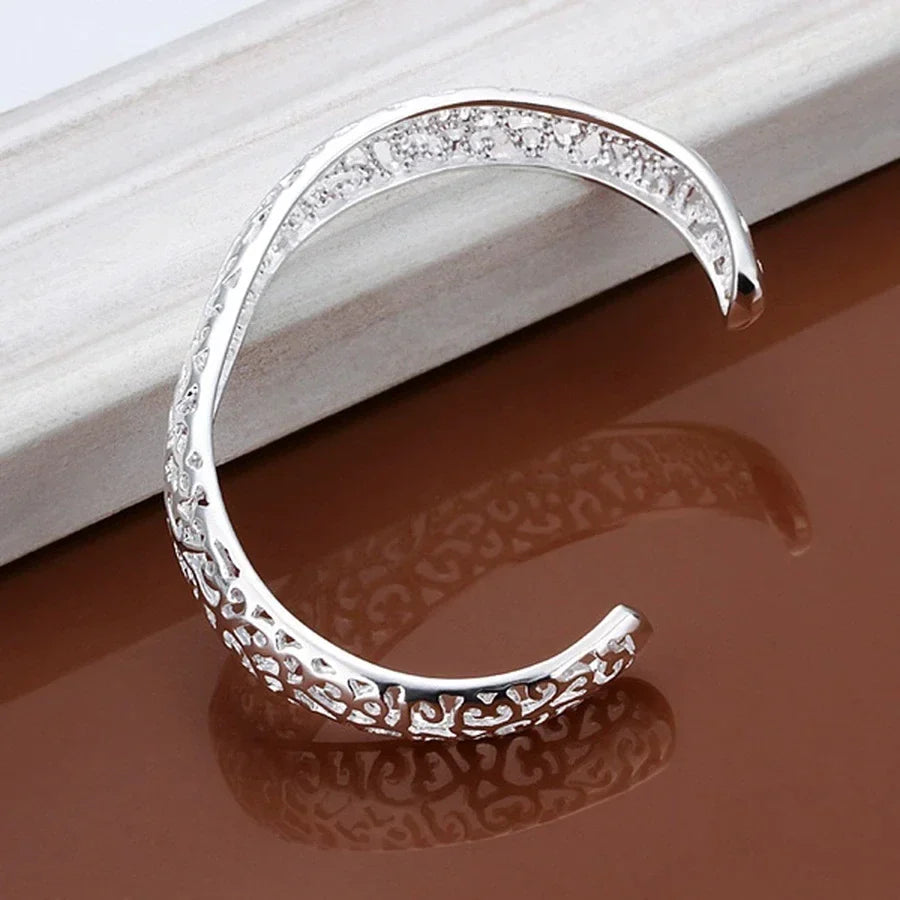Glänzendes, filigranes Silber Damen Manschettenarmband am Handgelenk. Zeitloser, eleganter Schmuck.