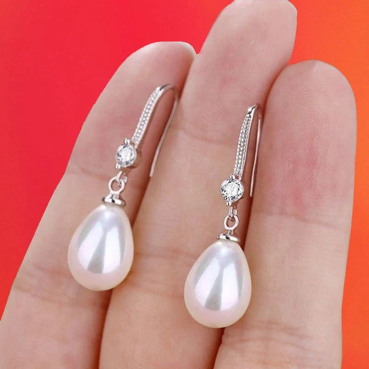 Zeitlose Eleganz: Damen-Ohrhänger aus 925er Silber mit ovalen weißen Perlen, ideal für festliche Looks.